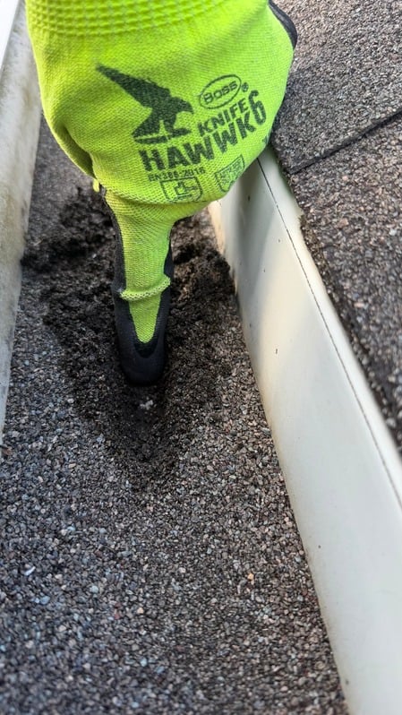 Technician inspecting a gutter corner