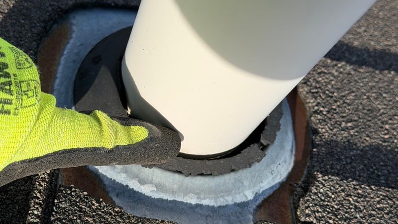 Technician resealing a roof vent