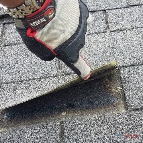 Technician inspecting a ridge cap shingle