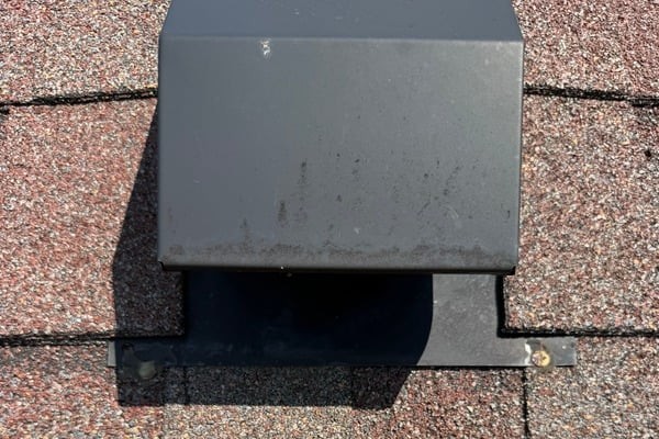 Roof vent cover on a shingle roof